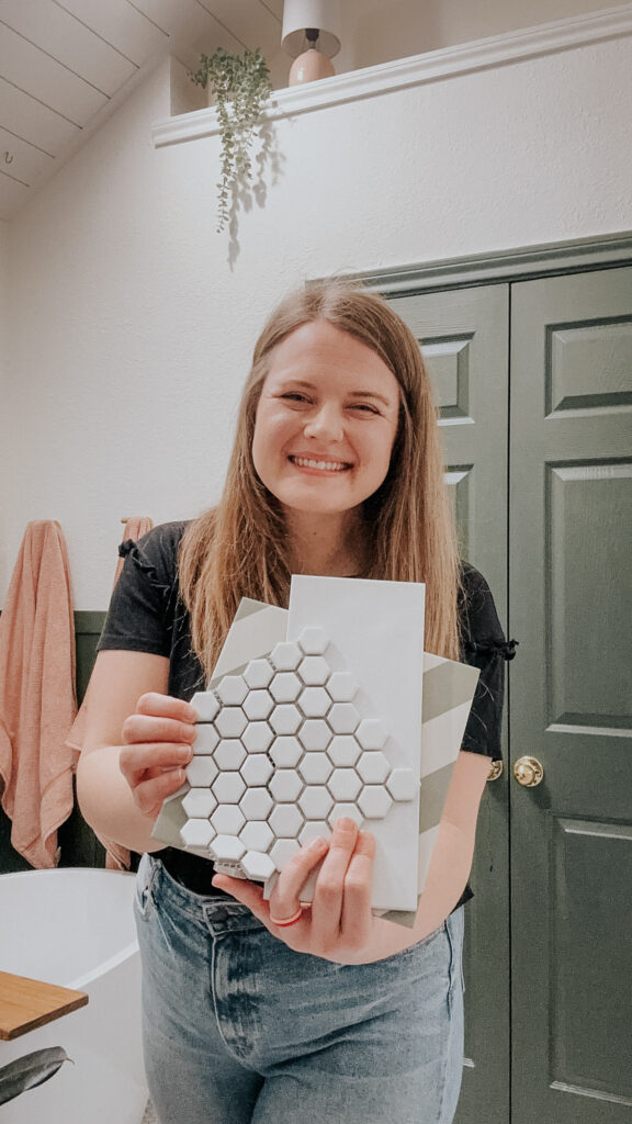 woman holding tile samples in a green bathroom