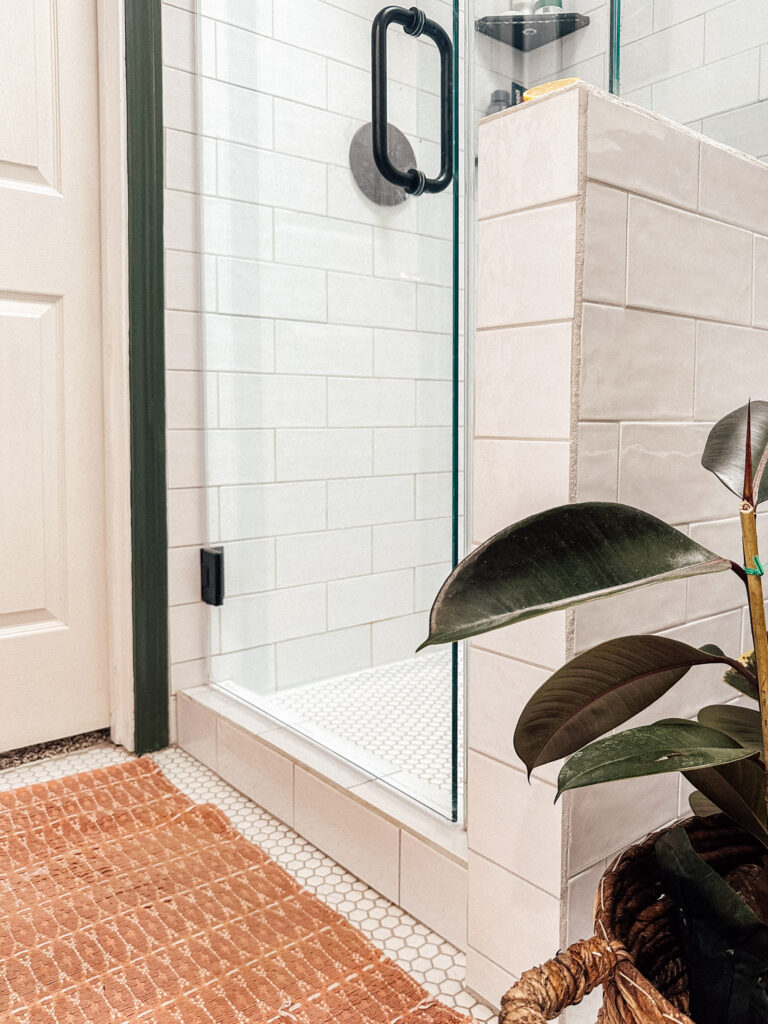 white subway tile shower with a white hex tile floor