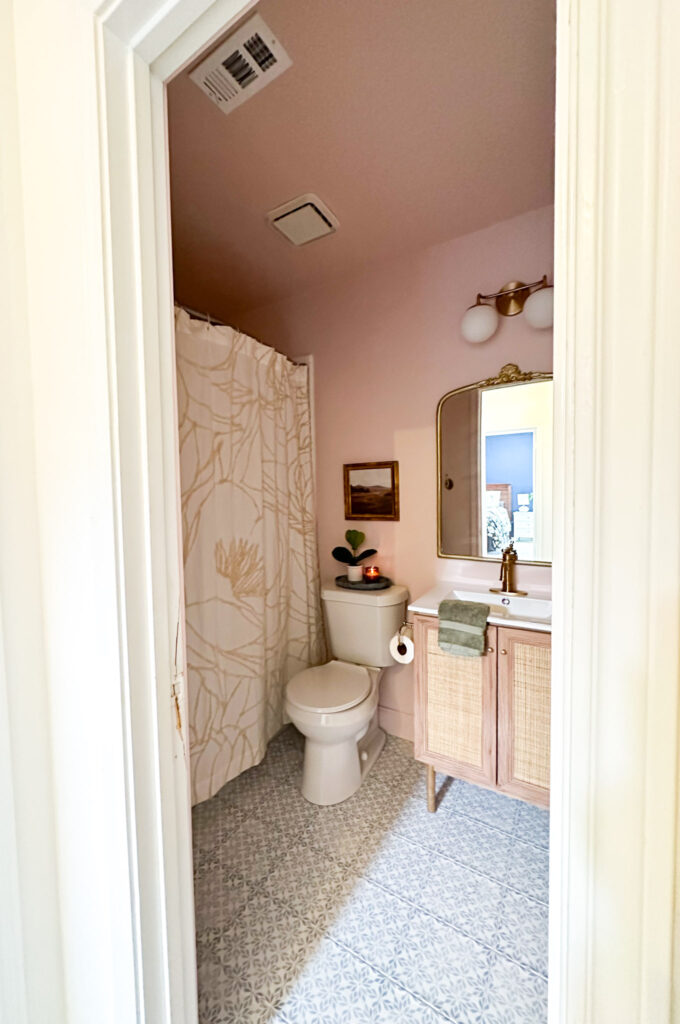 blue patterned floor tile in a small pink bathroom