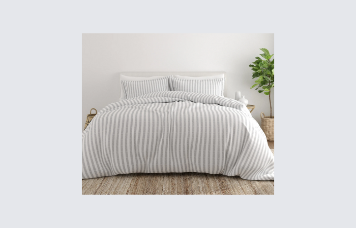 blue and white striped duvet cover in a white room with wood floor