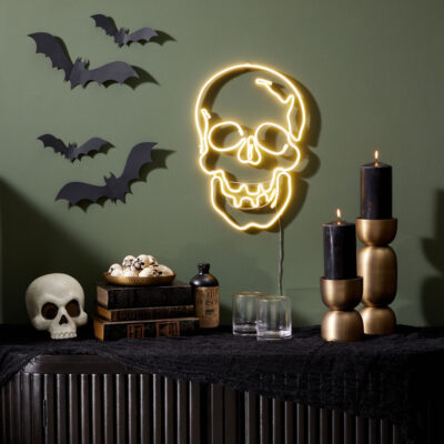 lit-up skull LED light on a green wall with spooky halloween wall decor