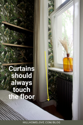 Bedroom with floor-length curtains next to a window with an amber vase. The text emphasizes that curtains should always touch the floor for a polished look.