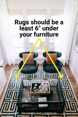 Living room with a bold patterned rug, where the text advises rugs should be placed at least 6 inches under the furniture for a cohesive look.