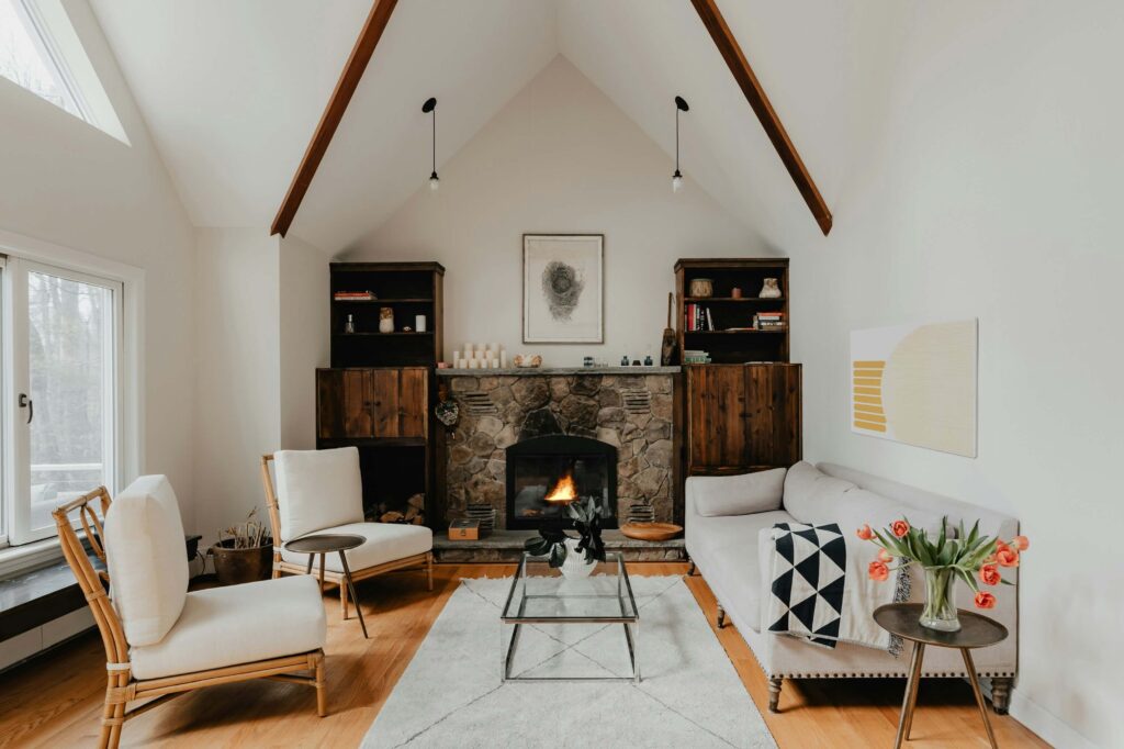 Modern white living room with short rustic stone fireplace and cabinets on both sides